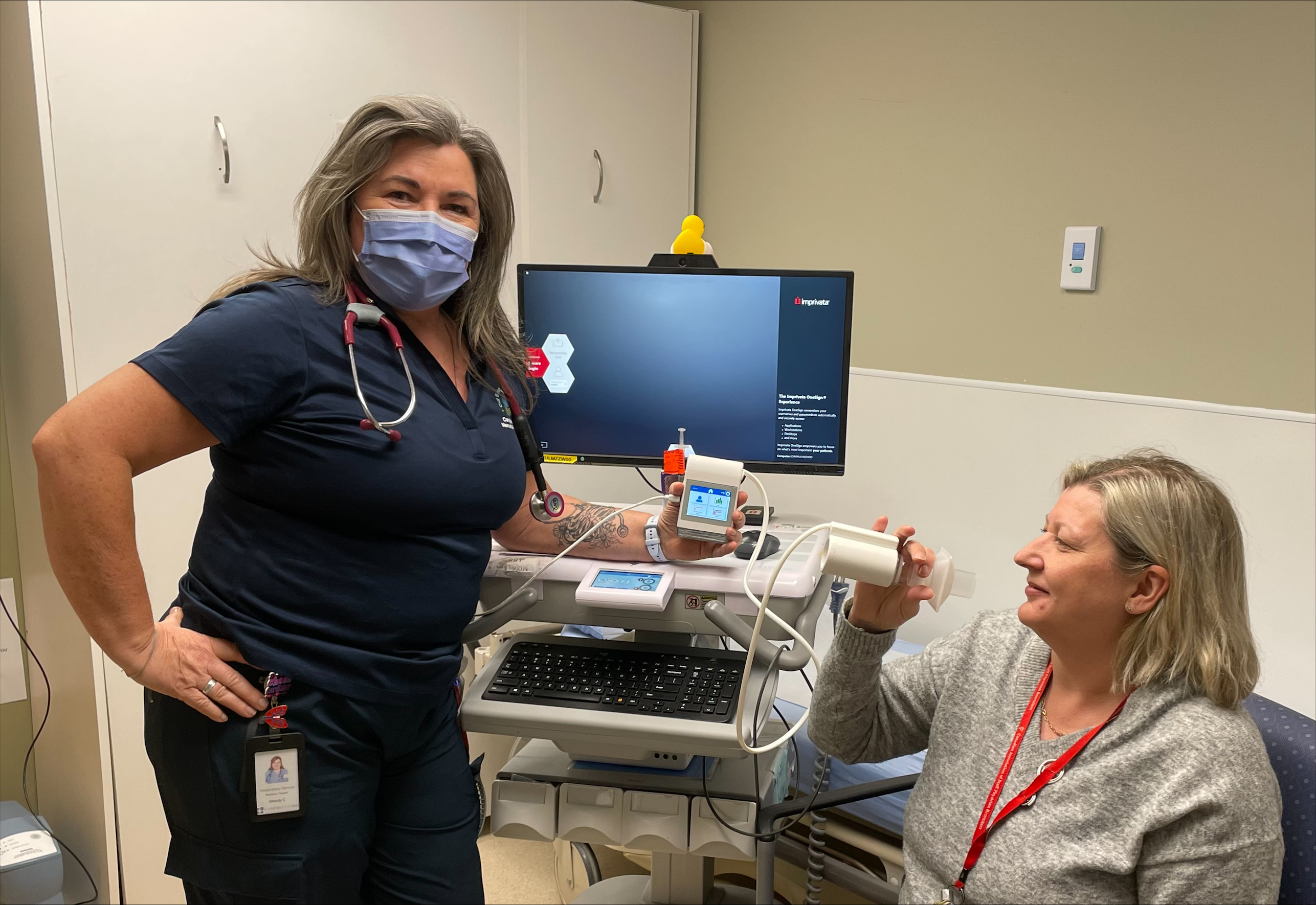 Respiratory Therapist Wendy Cross and Medical Affairs Coordinator Michele Haddow demonstrating Pulmonary Function Testing equipment